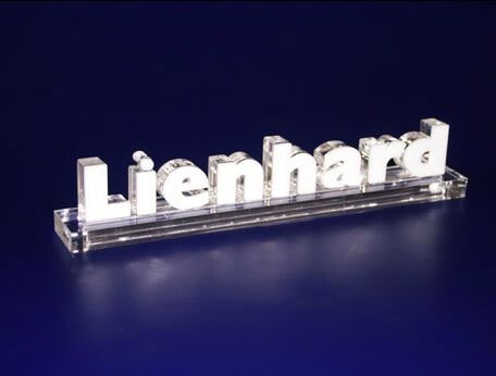 Transparenter "Lienhard"-Schriftzug auf blauem Hintergrund, elegant beleuchtet und modern gestaltet.