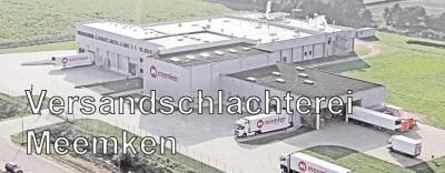 Großer Schlachthof mit geparkten LKWs in ländlicher Umgebung, keine sichtbaren Aktivitäten.