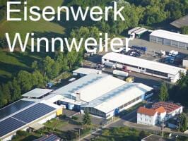 Luftaufnahme eines Industriekomplexes mit weißen Gebäuden, umgeben von grüner Vegetation.