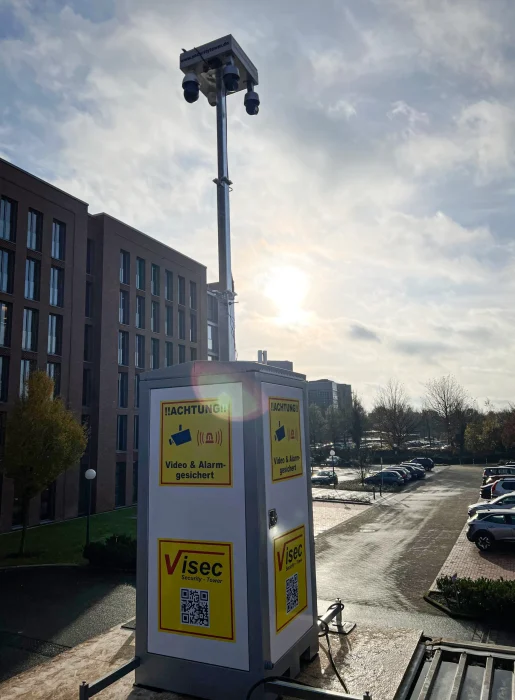 Mobiler ViSec Security Tower mit Videoüberwachung und Alarmfunktion, aufgestellt vor modernen Gebäuden.